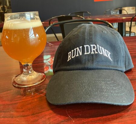 image of run drunk hat with a beer next to it